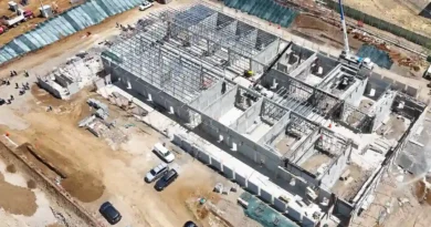 Vista aérea de dron que muestra el progreso de las obras de la megacárcel Cacco en Costa Rica, con múltiples edificios en construcción y maquinaria pesada operando.