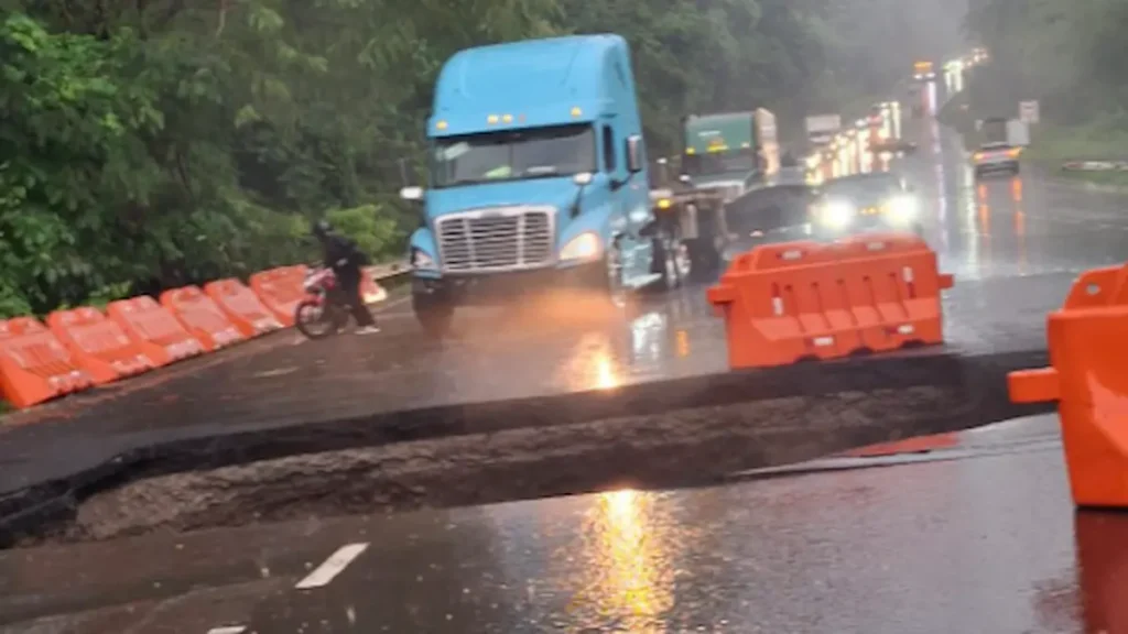 Gran hundimiento en el asfalto y camiones varados debido al cierre total provocado por el hundimiento en la ruta concesionaria de Ruta 27 en Costa Rica