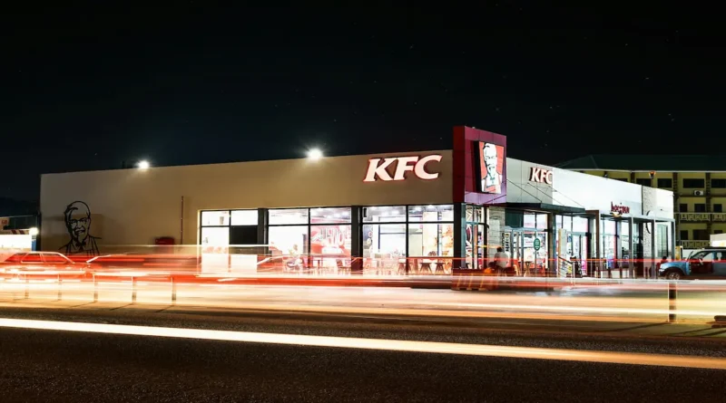 Fachada iluminada de un restaurante de comida rápida que ilustra cómo KFC desembarca en Nicaragua con sus nuevas sucursales.