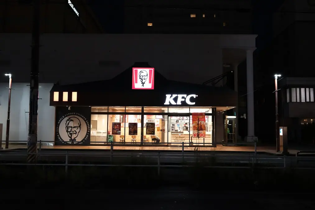 Vista nocturna de un establecimiento comercial que representa el momento en que KFC desembarca en Nicaragua para competir en el mercado local.