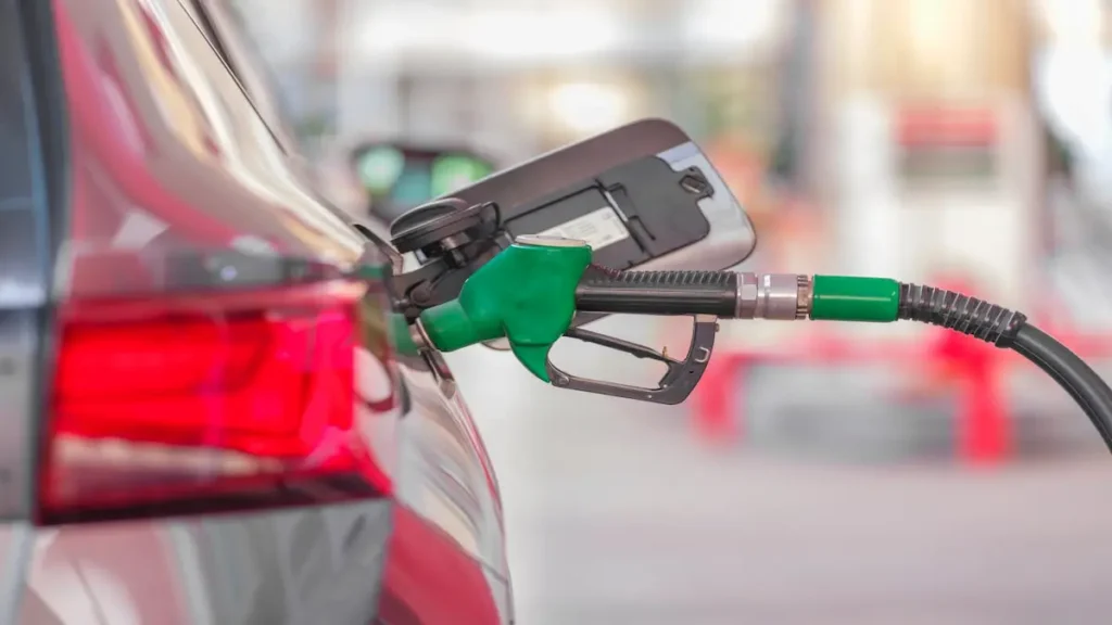 Manguera de gasolina recargando un vehículo en una estación de servicio, ilustrando los cambios en los precios de los combustibles en junio en Costa Rica.