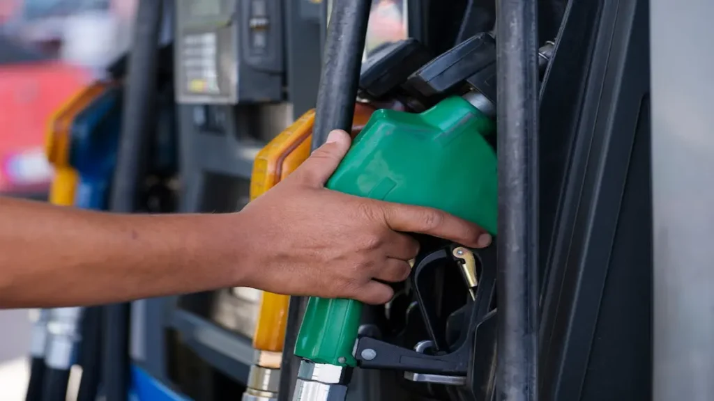 Mano sosteniendo una manguera de gasolina en una estación de servicio, representando el nuevo aumento en los combustibles aprobado por la ARESEP