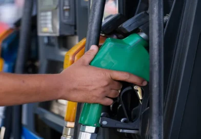 Mano sosteniendo una manguera de gasolina en una estación de servicio, representando el nuevo aumento en los combustibles aprobado por la ARESEP