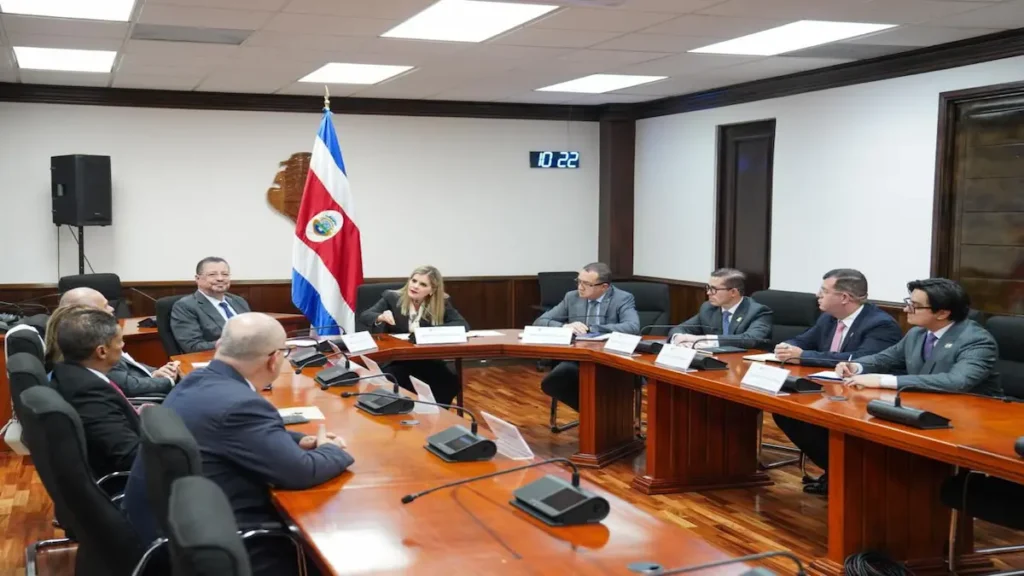 Mesa de negociación en Casa Presidencial donde Laura Fernández debate junto a la cúpula del Poder Judicial de Costa Rica frente a la bandera nacional.