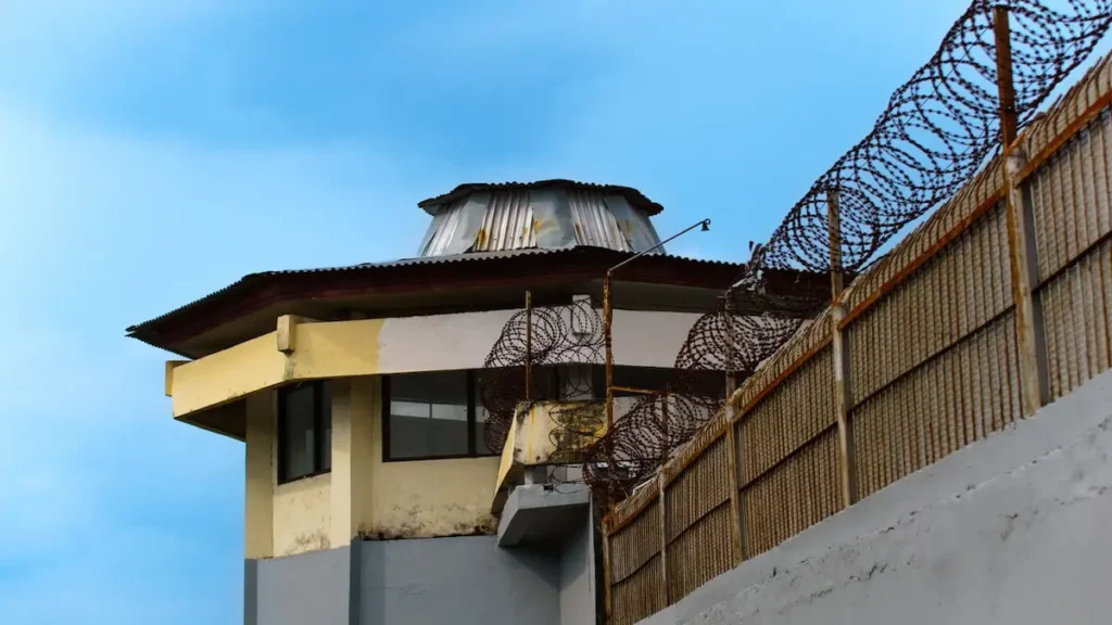 Torre de vigilancia de una cárcel rodeada de alambres de púas, en referencia a la reforma de seguridad en Costa Rica y el control carcelario.