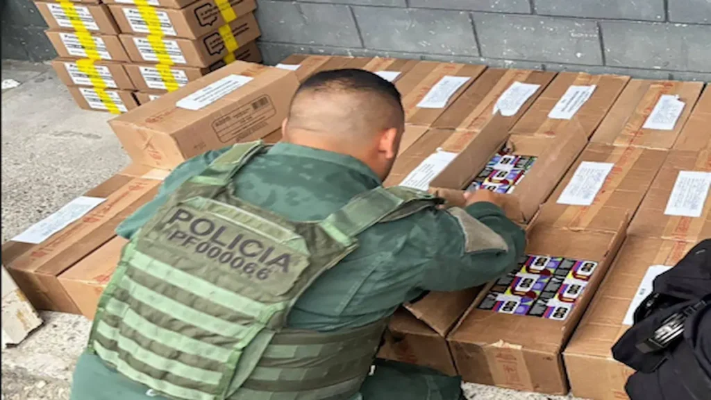 Oficial de la Policía de Fronteras inspeccionando el cargamento de álbumes y postales del Mundial decomisado por contrabando en Golfito.