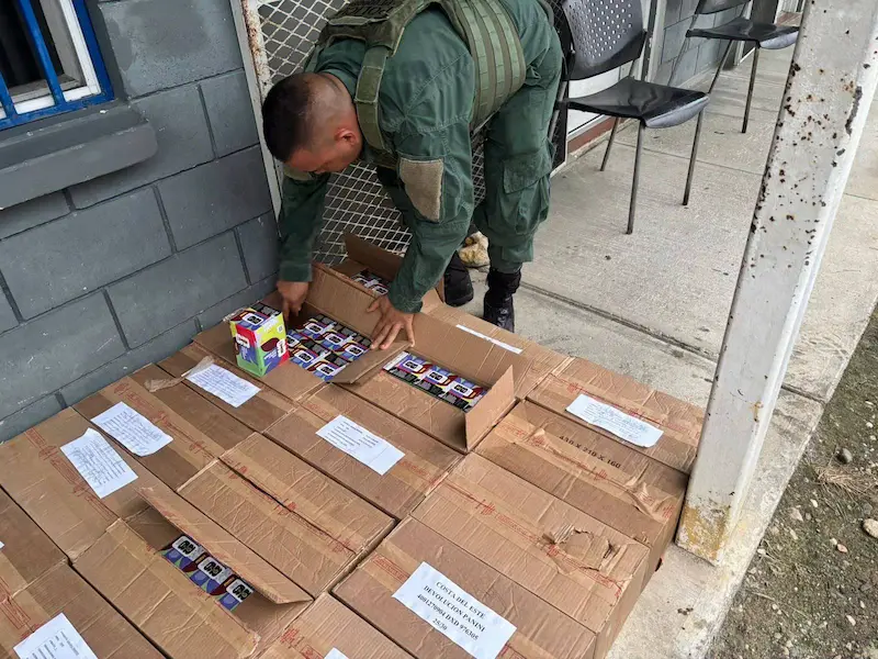 Oficial de la Policía de Fronteras revisando las cajas confiscadas con el cargamento de álbumes y postales en Golfito.