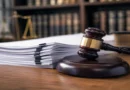 Mazo de juez de madera junto a una pila de documentos legales impresos que representan los nuevos proyectos de ley para la seguridad en Costa Rica.