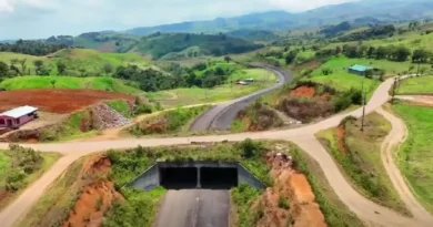 Vista aérea de un paso a desnivel y un tramo de asfalto rodeado de terrenos montañosos en la Carretera a San Carlos